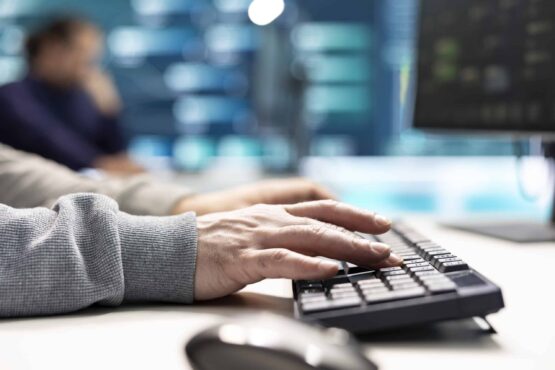 Governmental IT expert monitoring cyber threats on a computer and big screen
